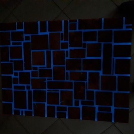Mosaikfliesen mit leuchtenden blauen Fugen bei Dunkelheit