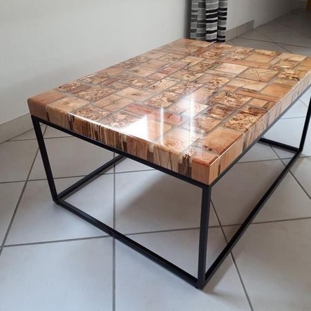 Quadratischer Couchtisch mit markanter Holzoberfläche und schwarzem Gestell