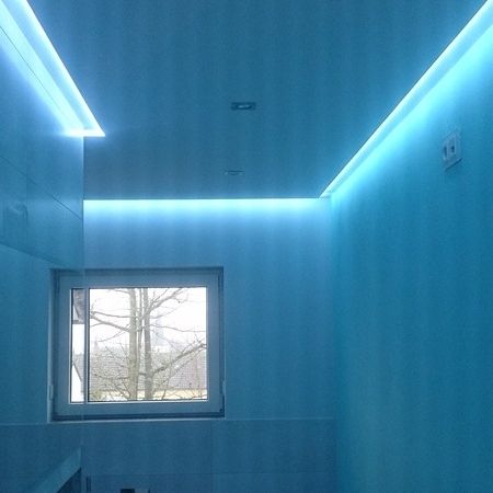 Raum mit blauer Wandverkleidung und indirekter LED-Beleuchtung