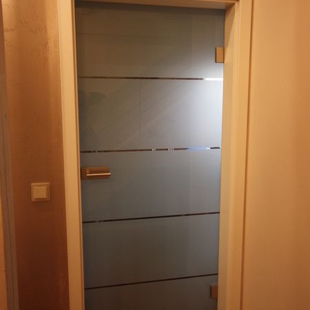 Durchgang mit Glas-Schiebetür und matter Fläche